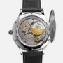 Close-up of the Chopard L.U.C XPS 1860 Officer Limited Edition For Hodinkee by Chopard, showcasing its detailed mechanical movement and gold rotor through the open case back, complemented by a black leather strap and refined white gold case.