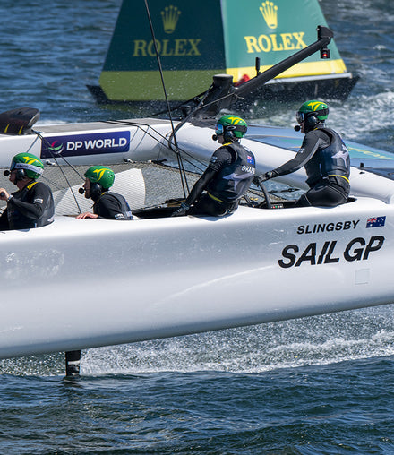 Four teammates working on a sail boat during competition