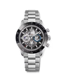 Silver chronograph watch with black bezel, skeletal dial showing visible mechanics, and stainless steel bracelet.
