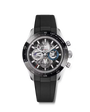 Silver chronograph watch with black dial, visible movement, and black rubber strap.