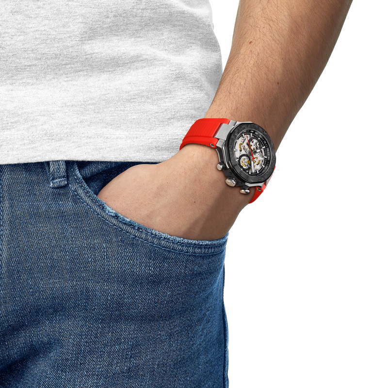Person wearing a watch with a red strap on a white background
