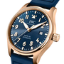 Rose gold watch with blue dial, white numerals and hands, date window, and blue rubber strap.