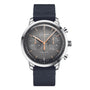 The Glashütte Original Sixties Chronograph Annual Edition is a stainless steel wristwatch with a textured gray dial, three subdials, rose gold hands, and a black fabric strap—an elegant homage to German watchmaking.