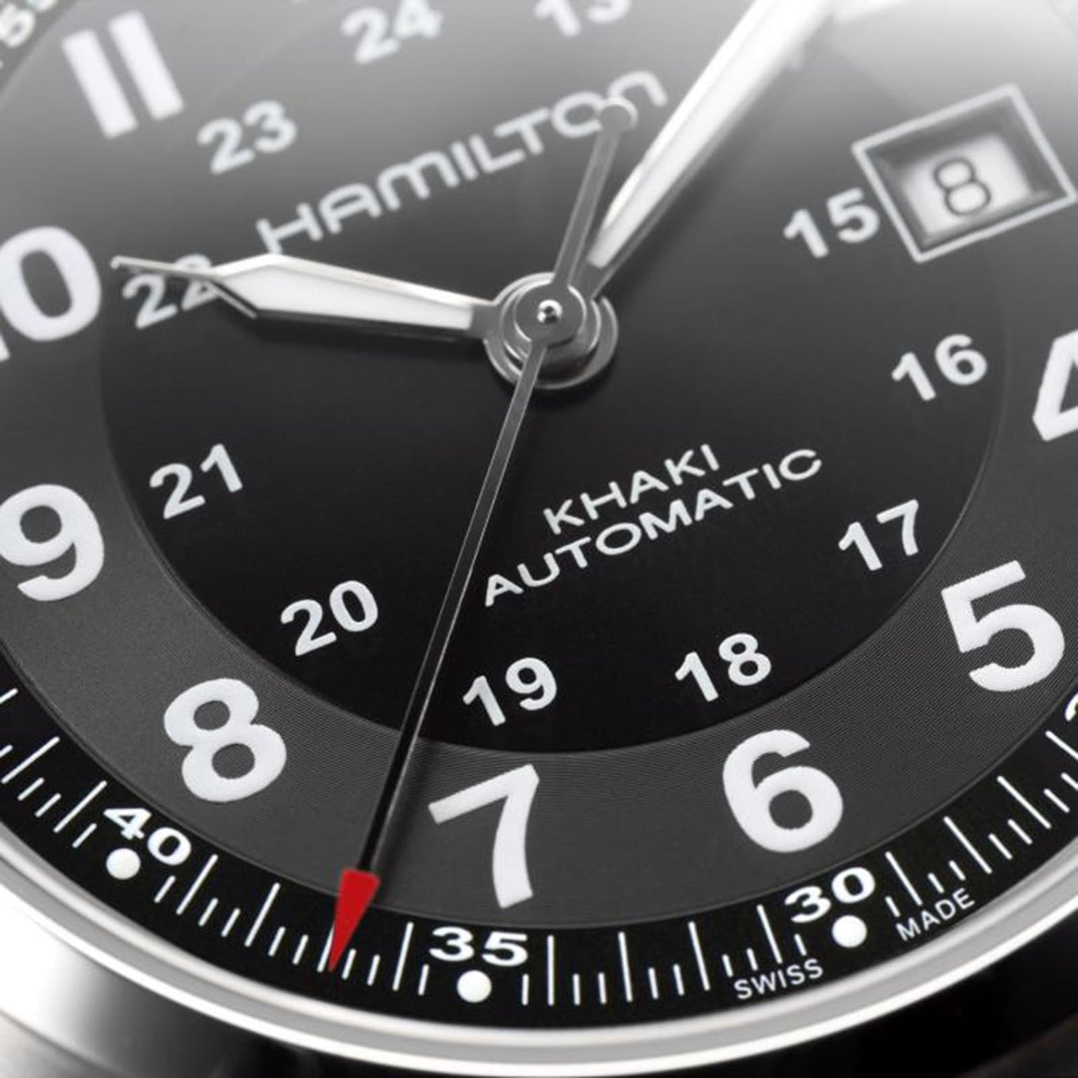 Close-up of a Hamilton Khaki Field Auto watch face in black, featuring numerals, hands, a date window at 8, and a red-tipped second hand, powered by the H-10 automatic caliber with impressive power reserve.