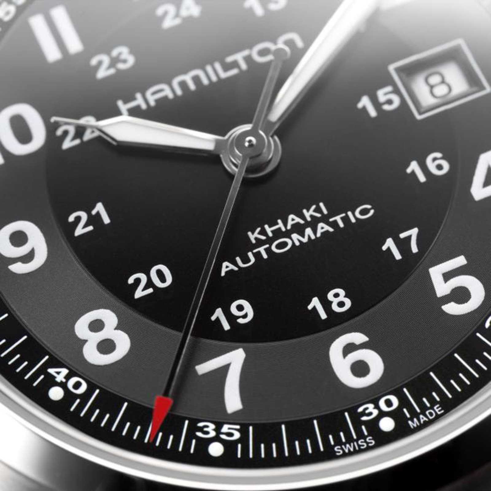 Close-up of a Hamilton Khaki Field Auto watch face in black, featuring numerals, hands, a date window at 8, and a red-tipped second hand, powered by the H-10 automatic caliber with impressive power reserve.