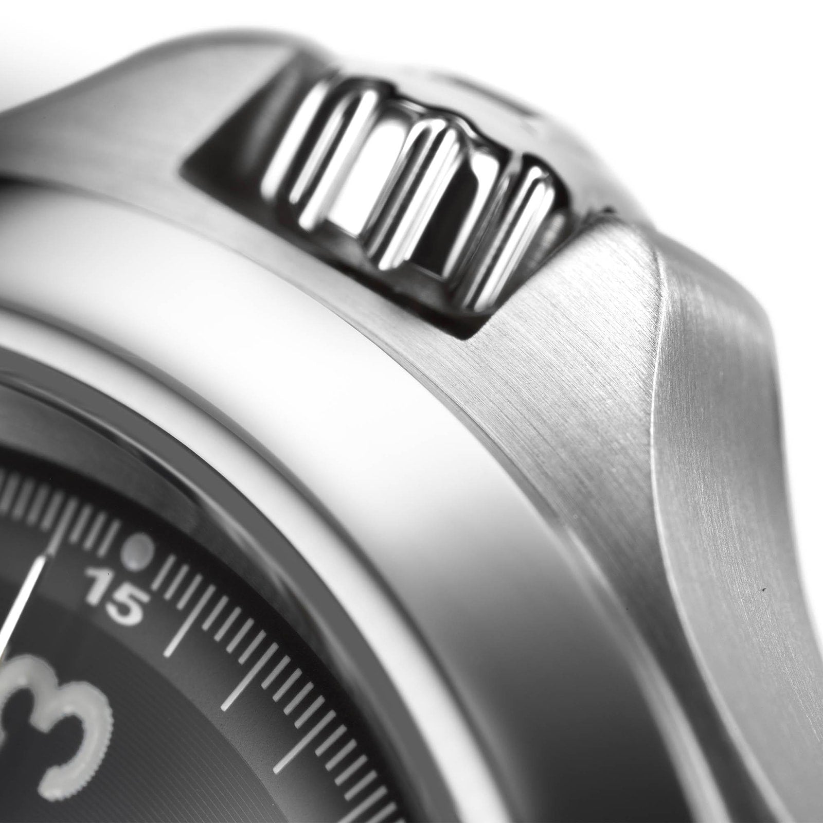 Close-up of the Hamilton Khaki Field King Auto’s stainless steel crown and bezel, showcasing brushed metal texture and a section of the dial with minute markers for legible military time reading.