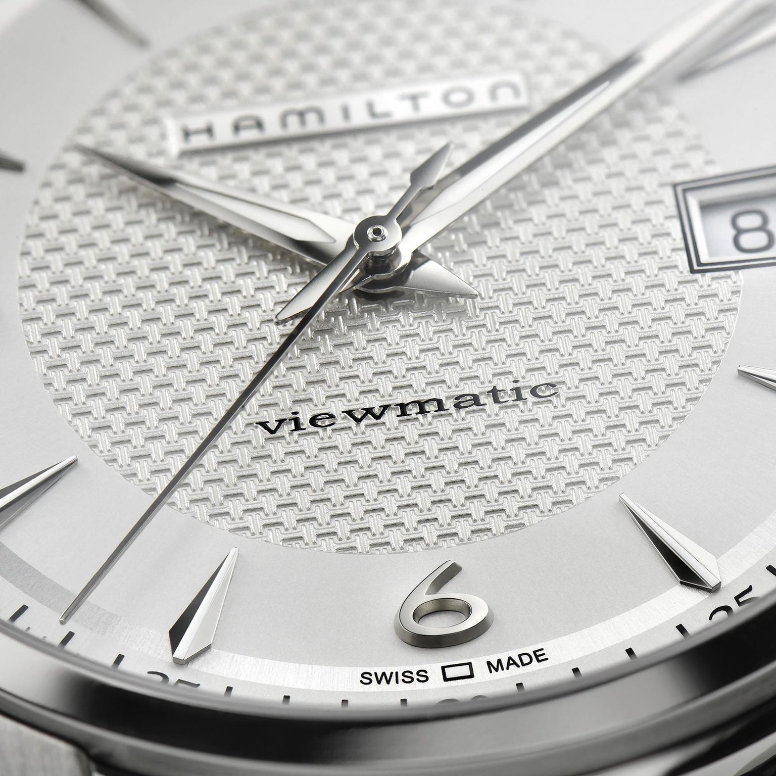 Close-up of the Hamilton Jazzmaster Viewmatic Auto watch face with silver hands, textured dial, date display, Swiss Made text, and the number 6—highlighting modern design and fine craftsmanship.