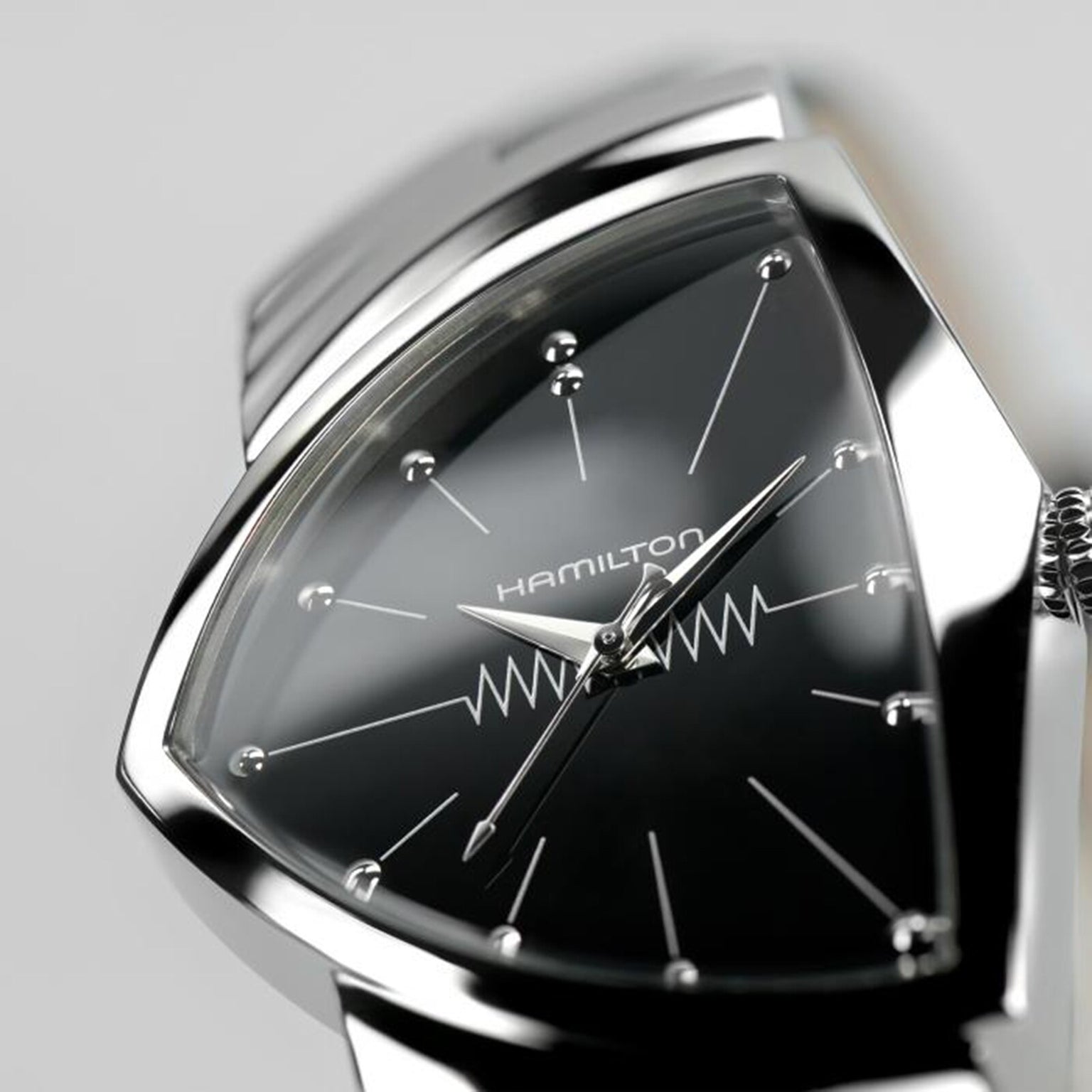 Close-up of the Hamilton Ventura Quartz wristwatch featuring a black triangular dial, silver hour markers, and zigzag design—an iconic Mid-Century Modern timepiece and the world’s first electrical watch.