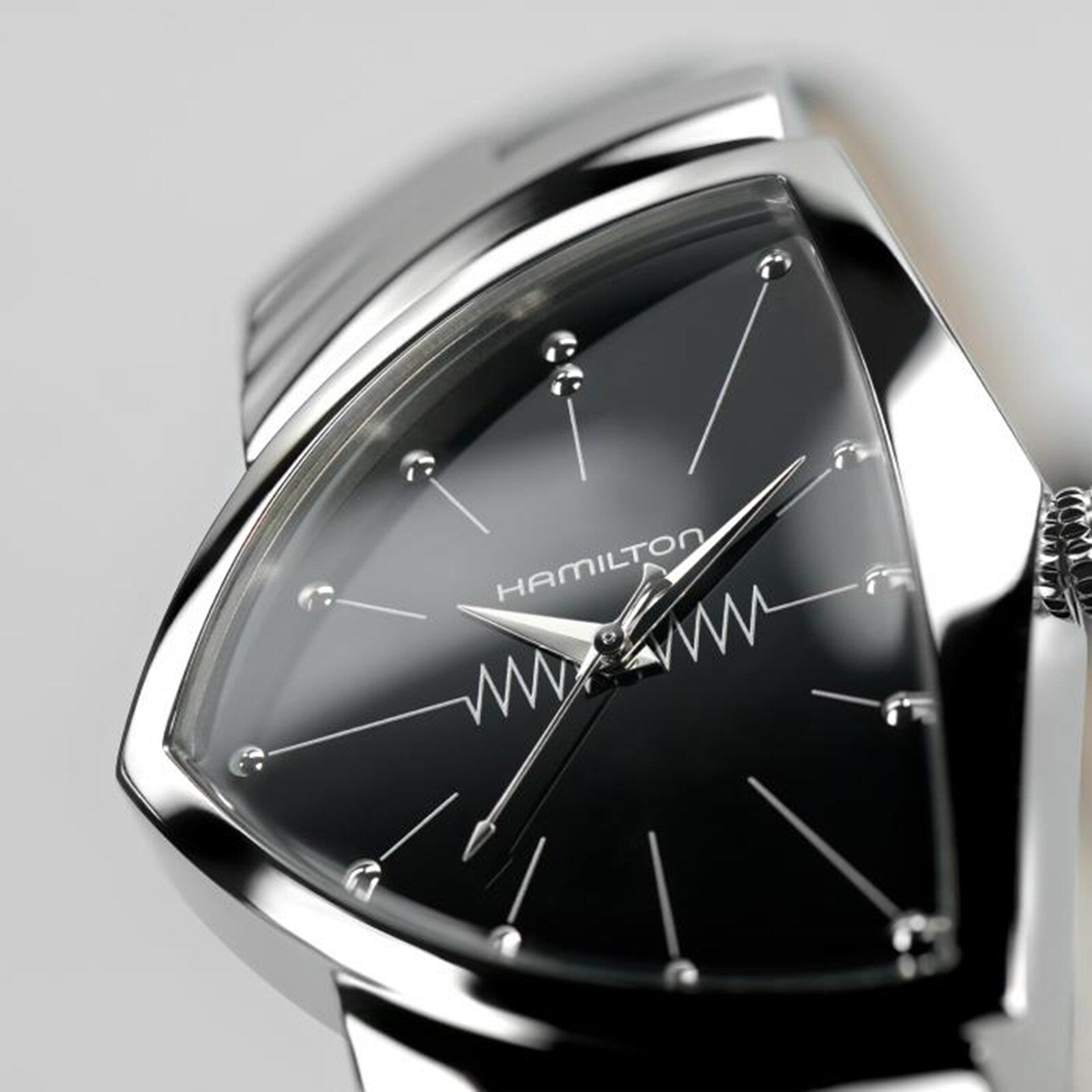 Close-up of the Hamilton Ventura Quartz wristwatch featuring a black triangular dial, silver hour markers, and zigzag design—an iconic Mid-Century Modern timepiece and the world’s first electrical watch.