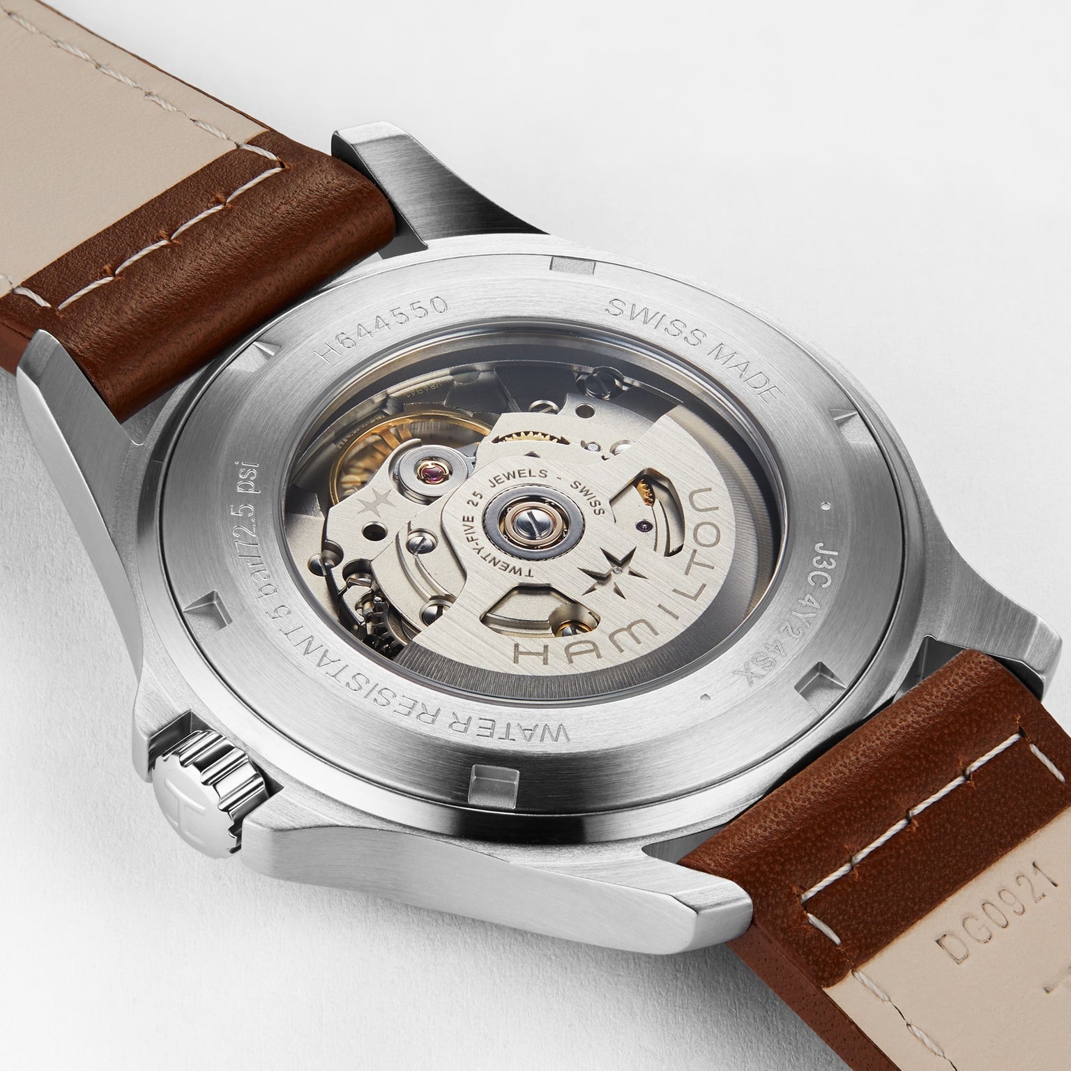 Close-up of the Hamilton Khaki Field King Autos back, featuring a transparent caseback displaying the automatic movement, signature crown protectors, and a brown leather strap.