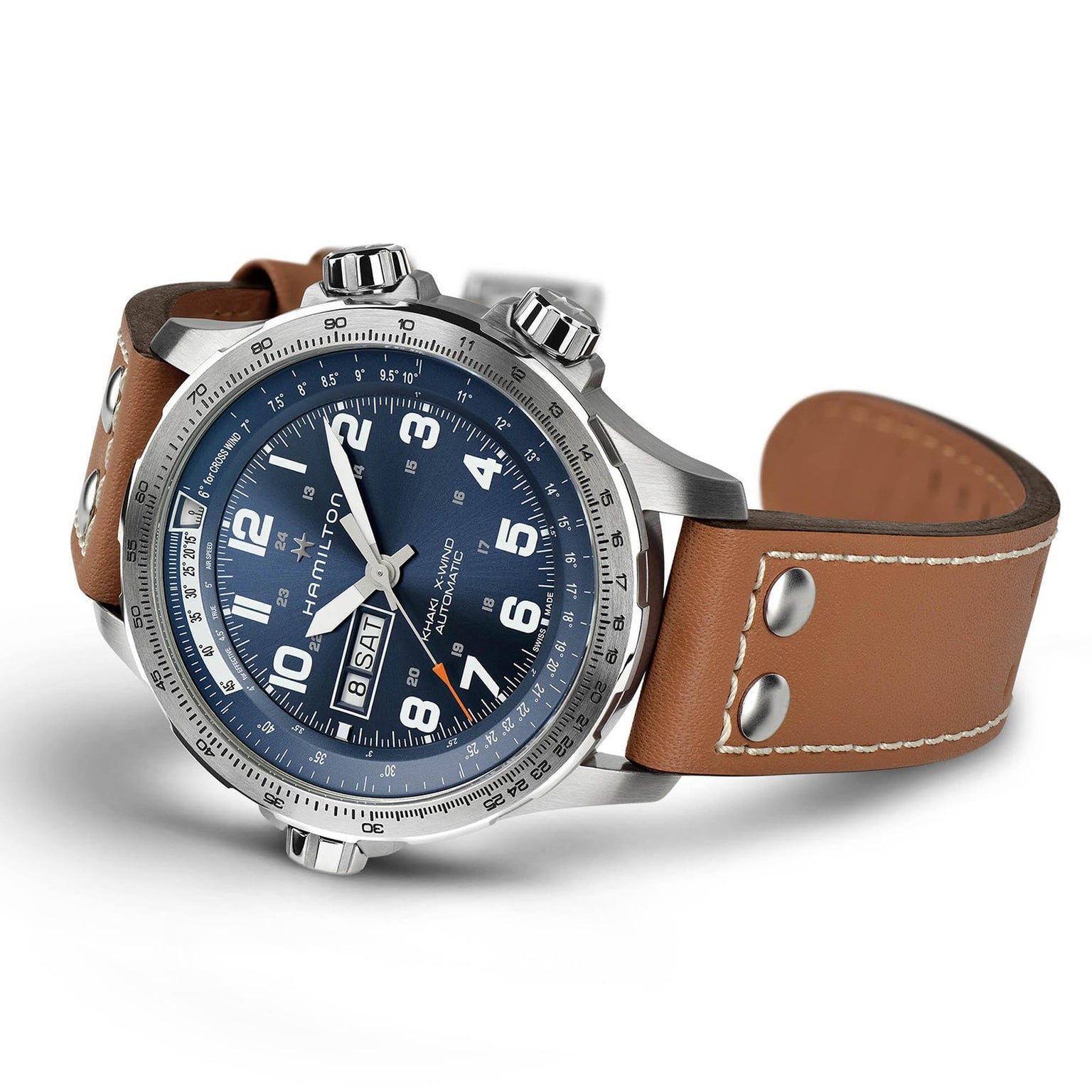 The Hamilton Khaki Aviation X-Wind Day Date Auto features a blue dial, silver case, three crowns, SuperLumiNova® numerals, date display, and a brown leather strap with white stitching and metal rivets.