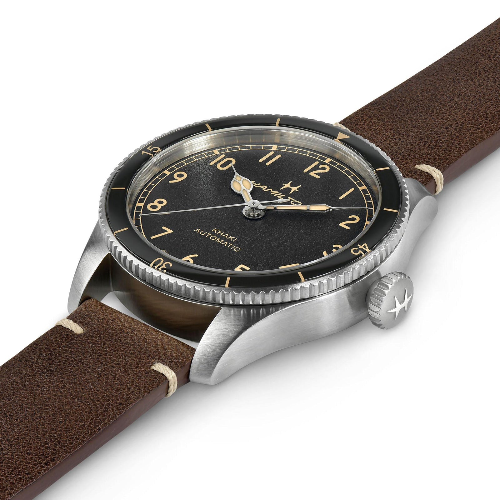 The Hamilton Khaki Aviation Pilot Pioneer is a stainless steel pilot watch with a black dial, gold numerals, and brown leather strap, shown from an angled side view—ideal for aviation enthusiasts.