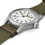 The Hamilton Khaki Field Mechanical, a silver wristwatch with a white dial and green fabric strap, is shown on a white background.