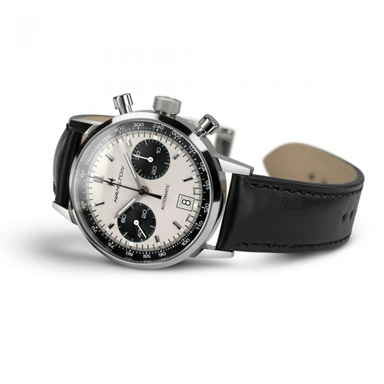 The Hamilton American Classic Intra-Matic Auto Chrono watch features a black leather strap, silver dial, and two black subdials, displayed at an angle.