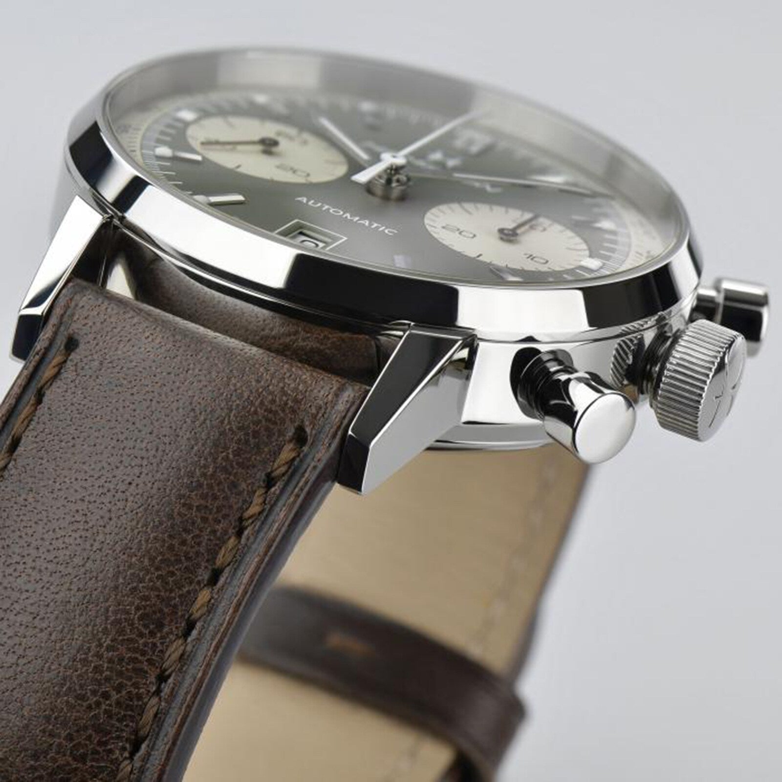 Close-up of the Hamilton American Classic Intra-Matic Auto Chrono 40mm, showing its vintage style with a brown leather strap, silver case, two pushers, crown, subdials, and AUTOMATIC text on the dial.