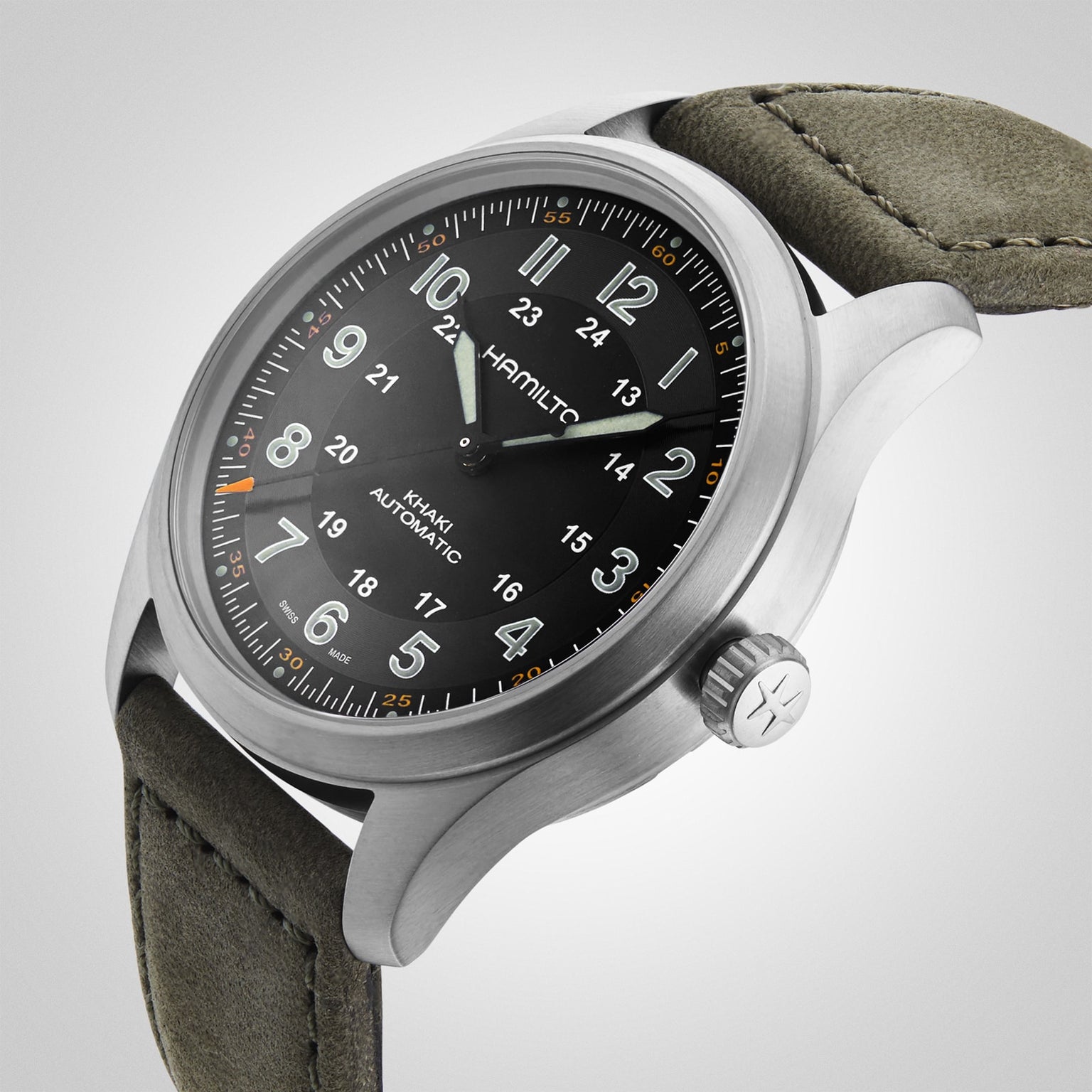 Close-up of a Hamilton Khaki Field Titanium Auto watch featuring a black dial, titanium case, olive green fabric strap, and white hour numerals.