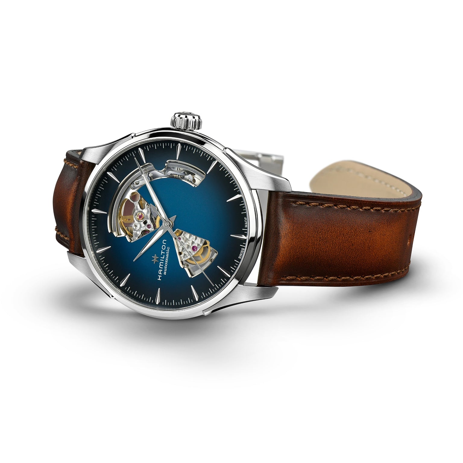 The Hamilton Jazzmaster Open Heart Auto features a brown leather strap, silver case, and blue smoked dial with visible mechanical movement for a modern look.