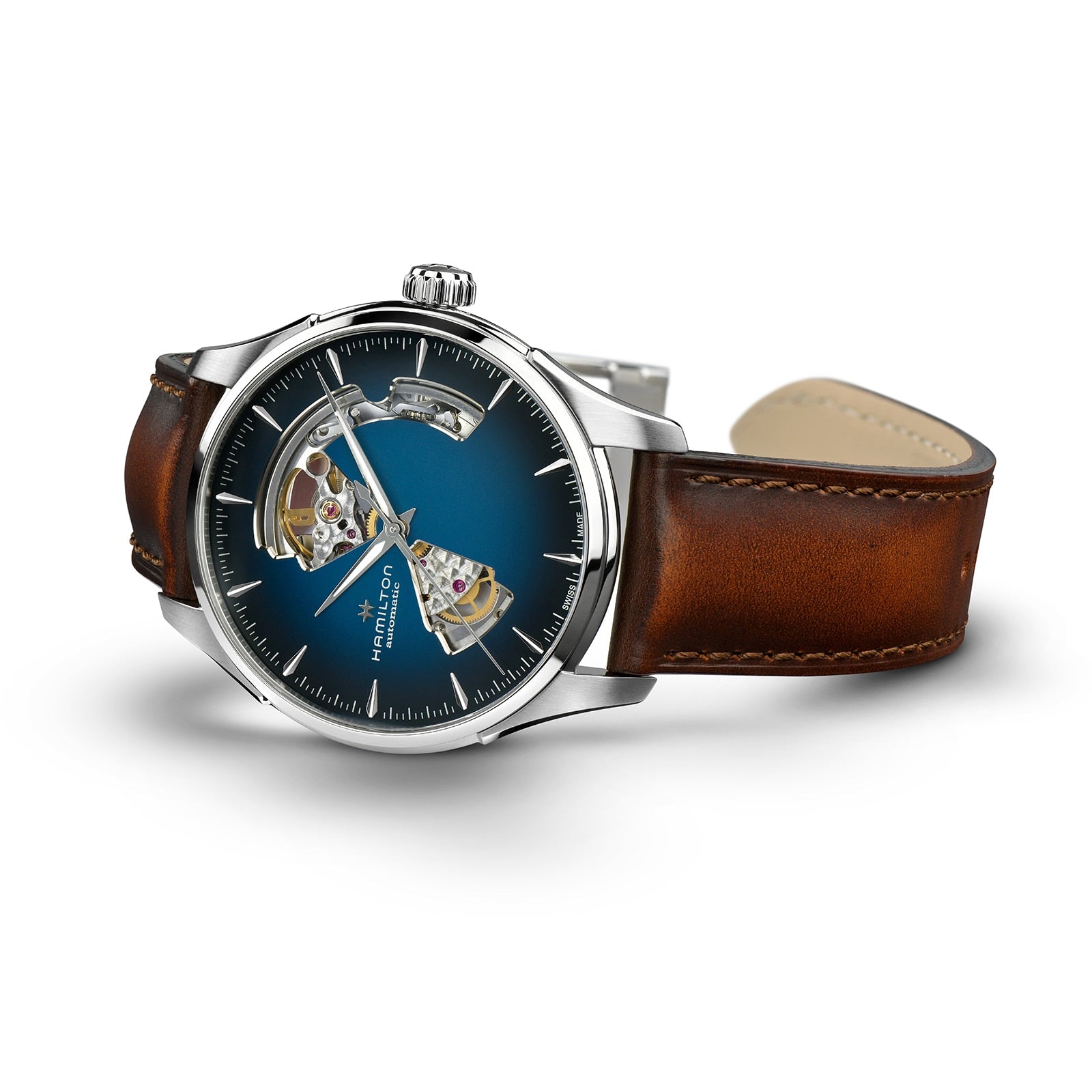 The Hamilton Jazzmaster Open Heart Auto features a brown leather strap, silver case, and blue smoked dial with visible mechanical movement for a modern look.