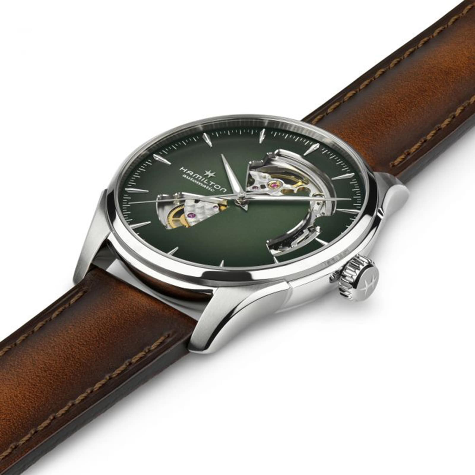 A Hamilton Jazzmaster Open Heart Auto wristwatch featuring a green smoked dial, silver case, exposed gears, and a brown leather strap is shown angled on a white background.