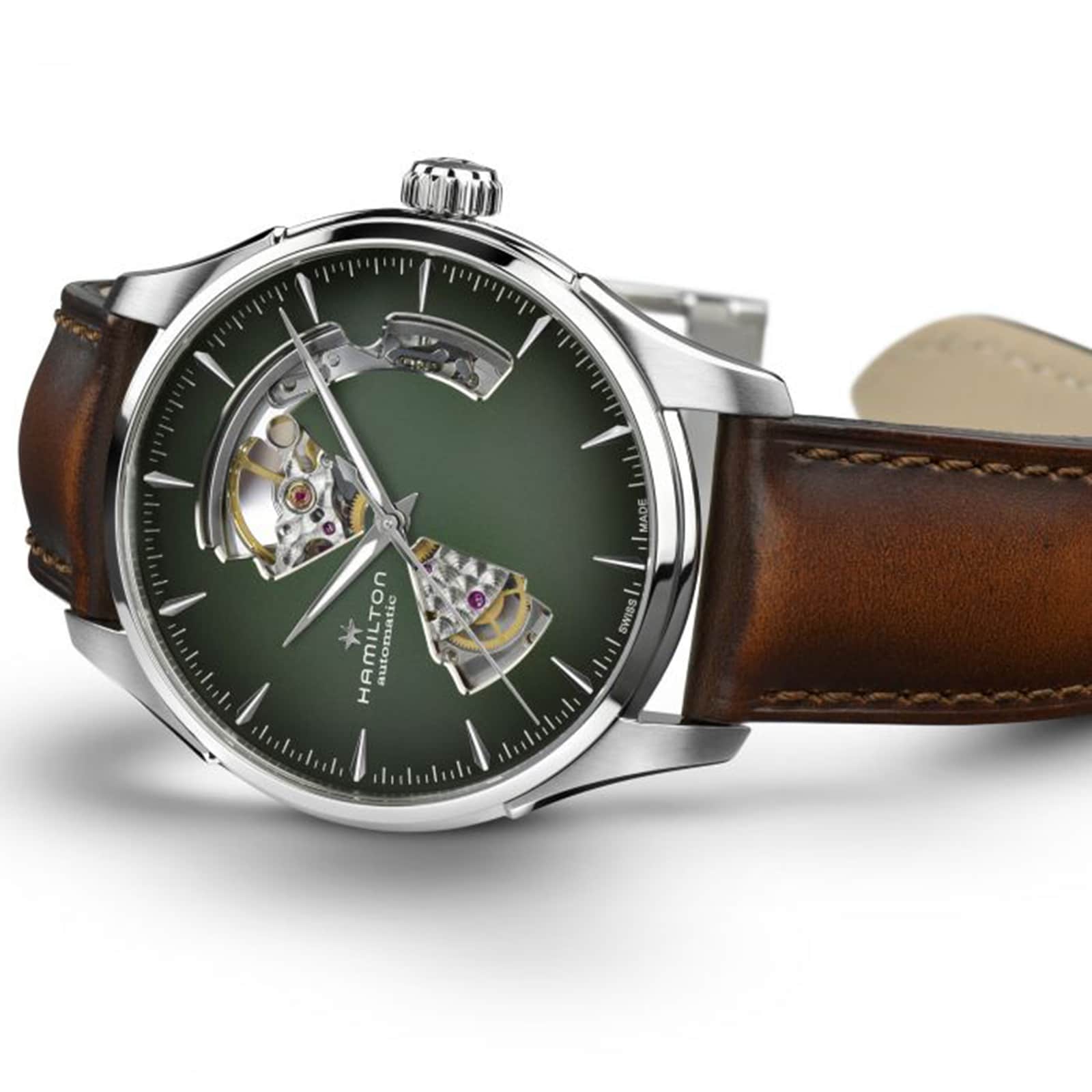 The Hamilton Jazzmaster Open Heart Auto features a green smoked dial, silver case, and brown leather strap, blending modern style with classic design.