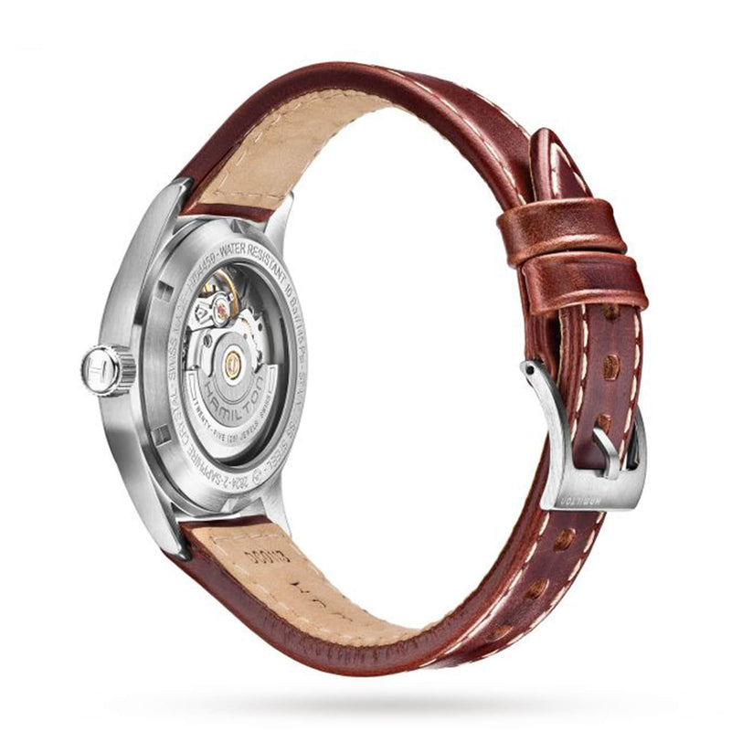 The Hamilton King Auto is a military-inspired watch with a brown leather strap and visible mechanical movement on its stainless steel case back, shown against a white background.