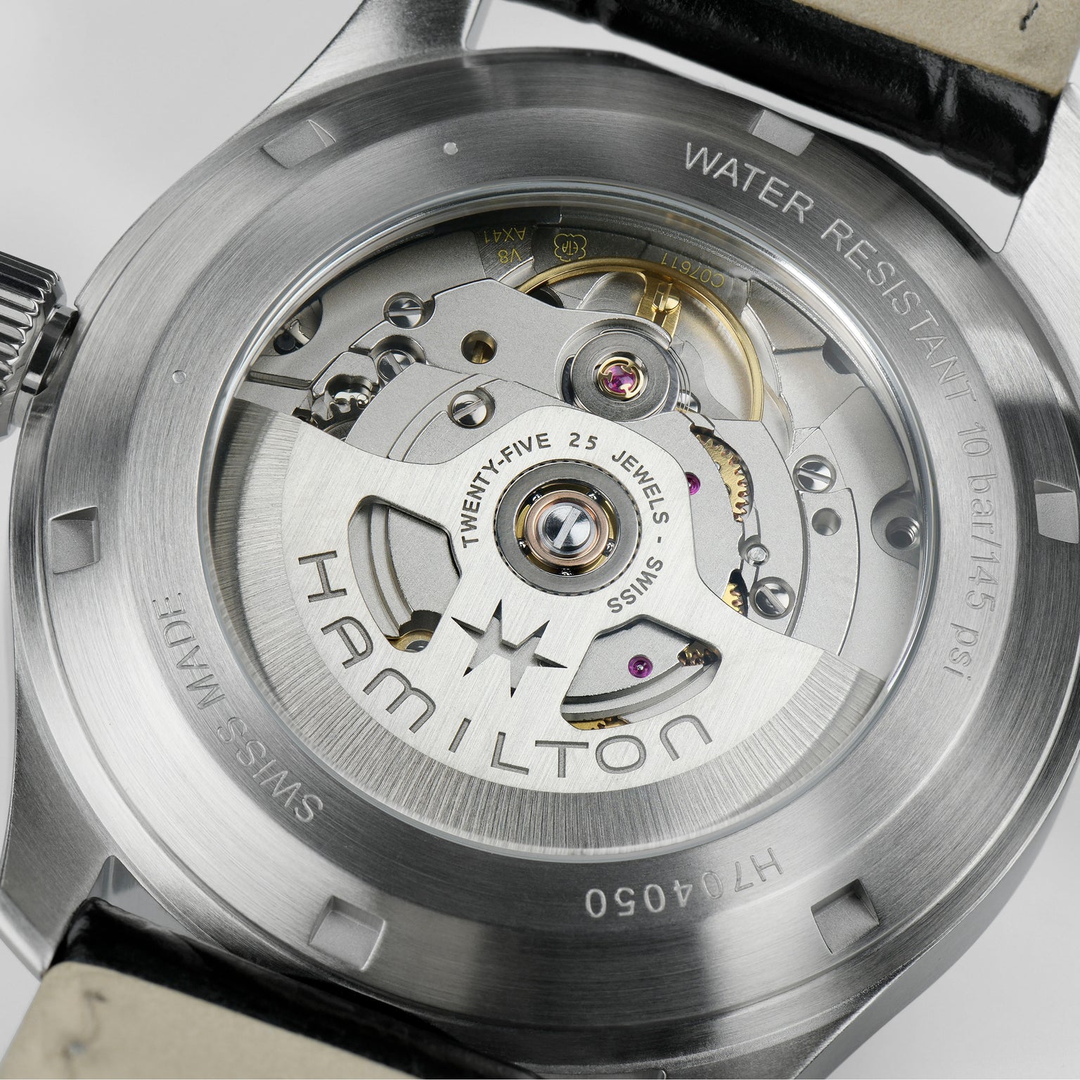 Close-up of the back of the Hamilton Khaki Field Murph 38mm watch, featuring an exposed automatic movement with 80-hour power reserve, engraved details, and a black leather strap.