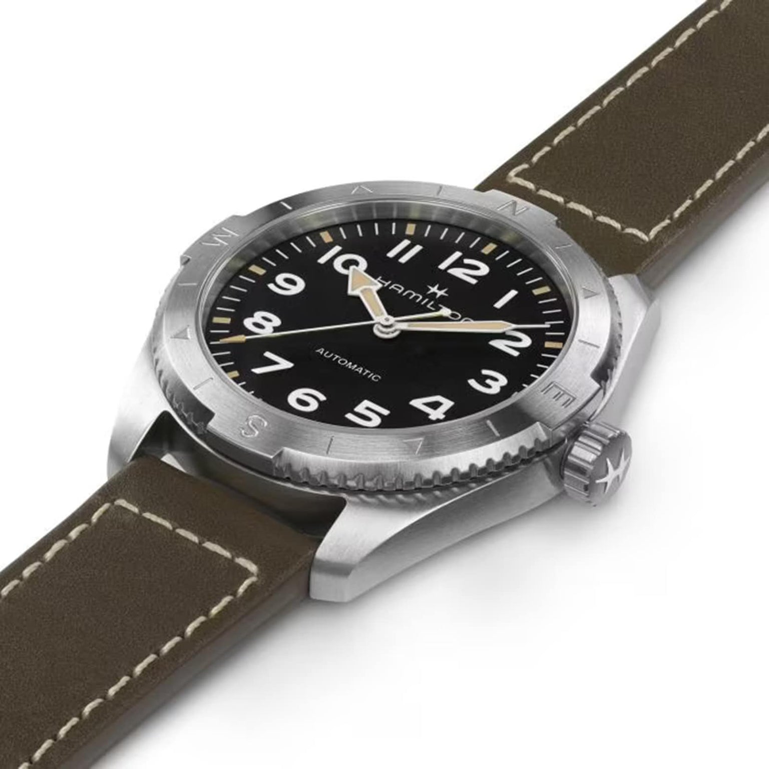 A close-up of the Hamilton Khaki Field Expedition Auto, showing its black dial with Super-LumiNova® numerals, stainless steel case and bezel, and brown leather strap with white stitching.