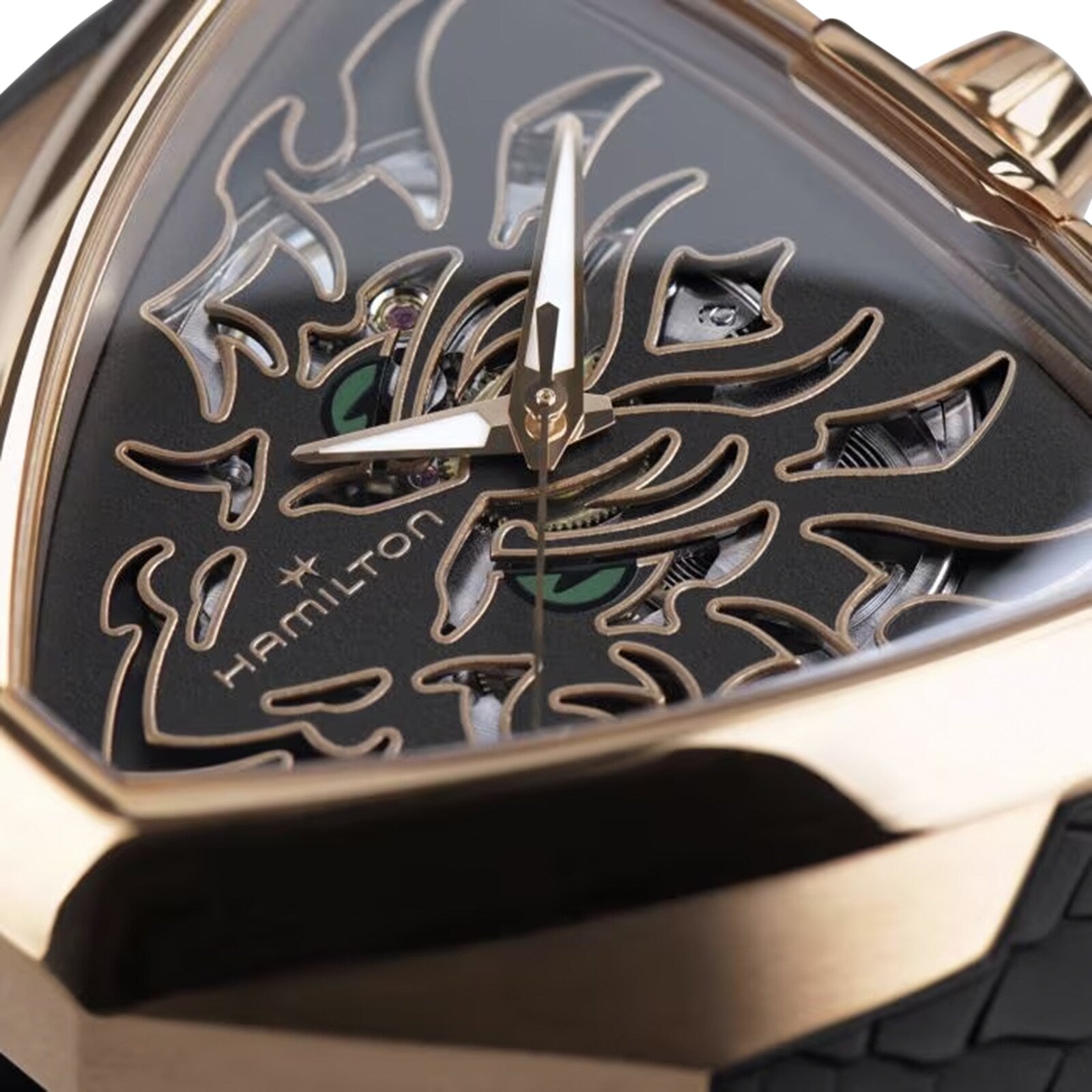 Close-up of the Hamilton Khaki Field King Auto watch featuring a gold case and a black, triangular face with a flame-like skeleton design.