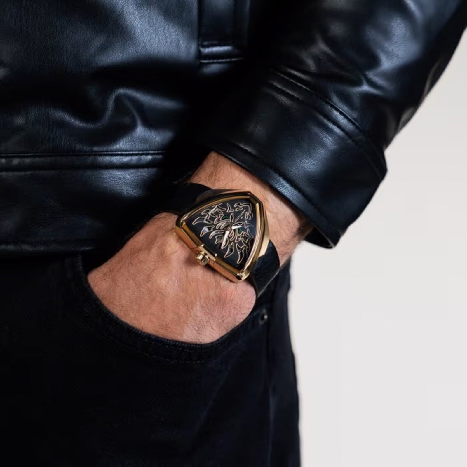 A person wearing a black leather jacket and a distinctive Hamilton Khaki Field King Auto watch, their hand in a pocket.