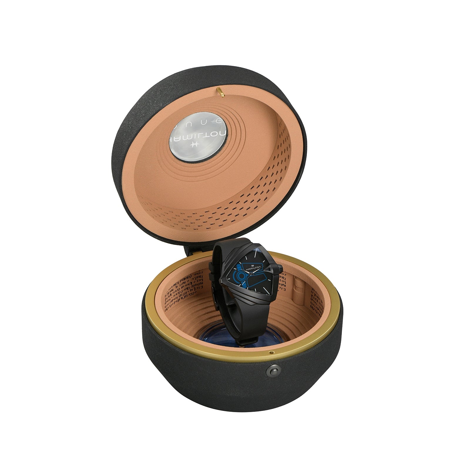 The Hamilton Ventura XXL Bright Dune Limited Edition, a black wristwatch with a blue-accented face, is shown in an open, round padded case with a textured exterior and tan interior, featuring commemorative packaging for this exclusive model.