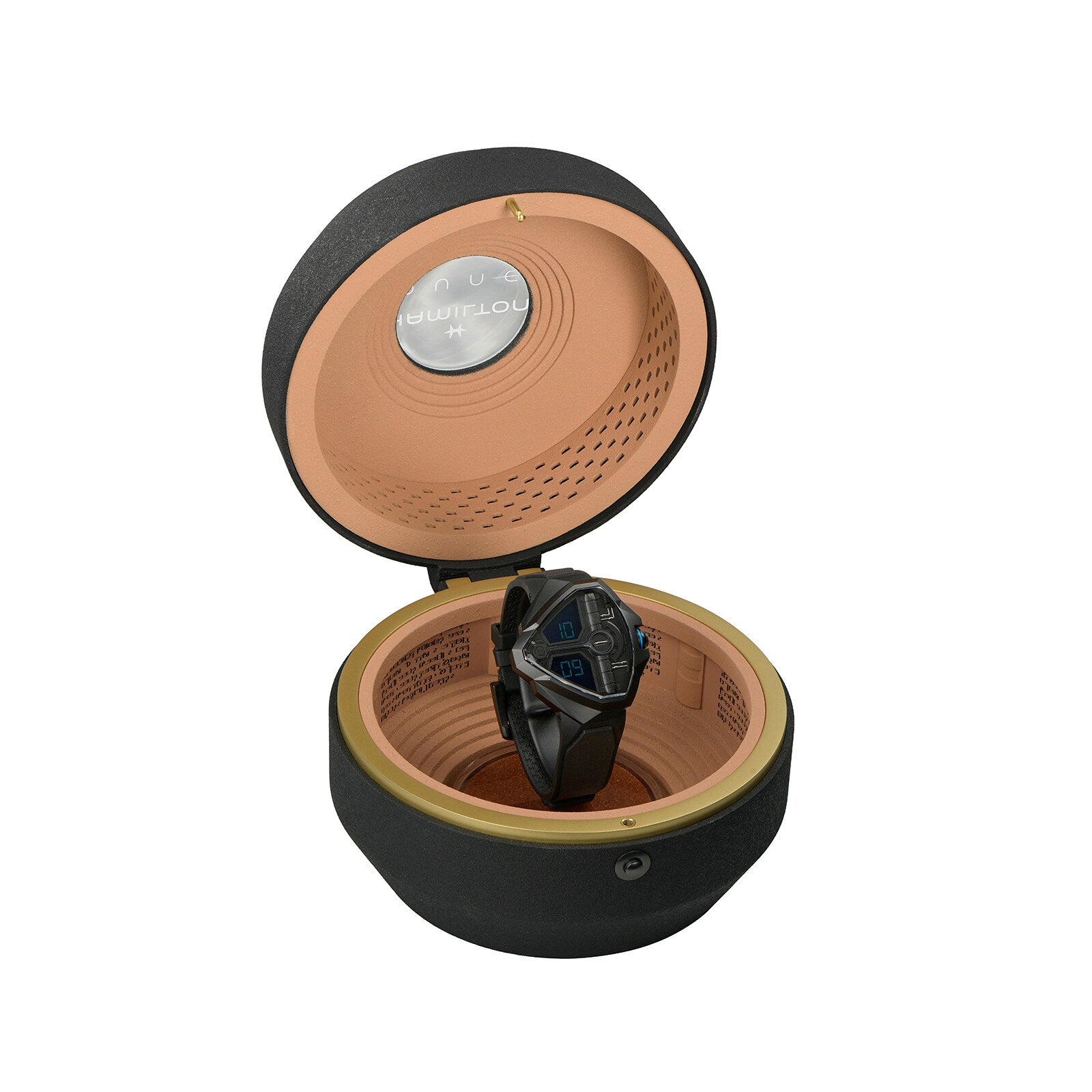 The Hamilton Ventura Edge Dune Limited Edition black wristwatch is displayed inside an open, round watch winder with a tan interior and a black exterior.