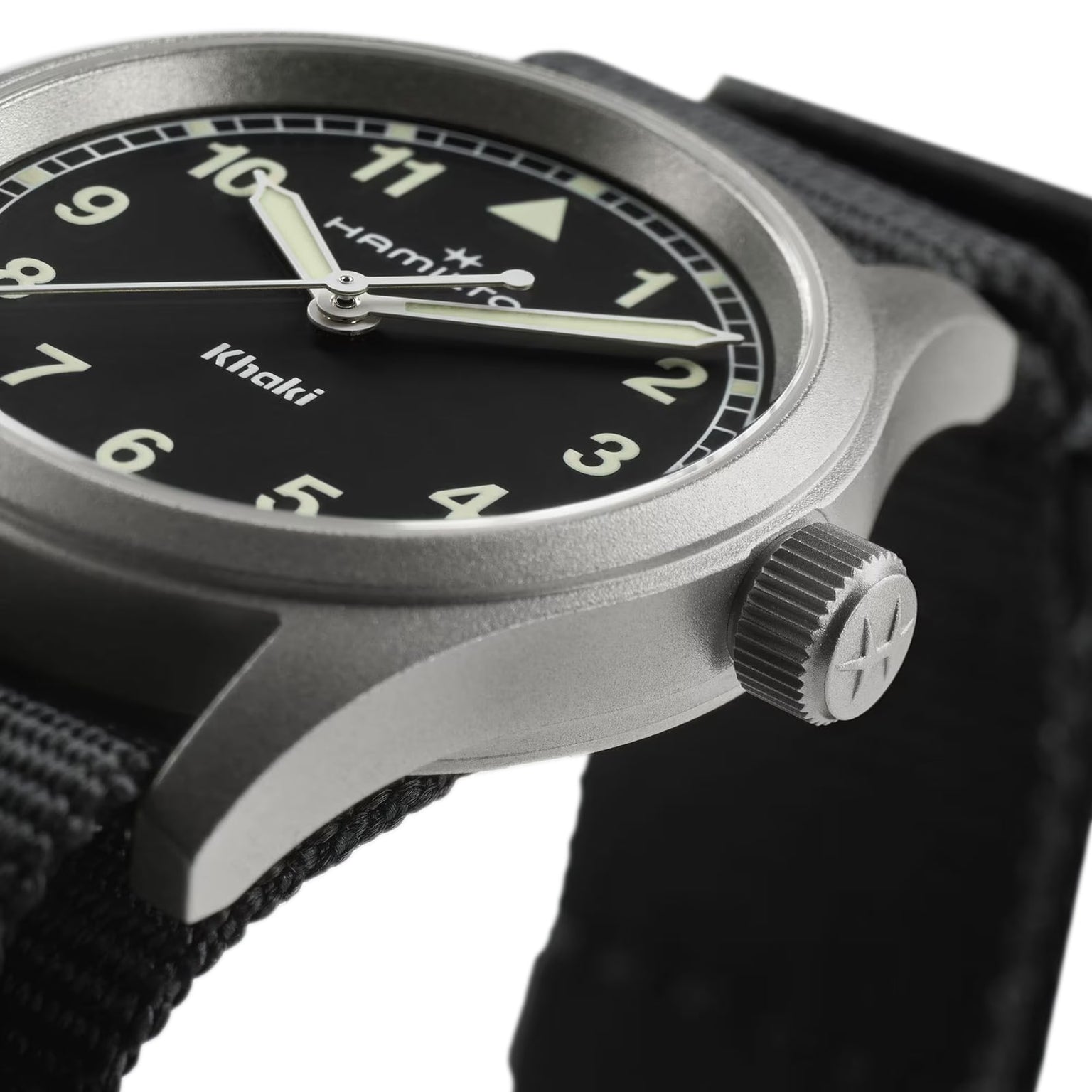 Close-up of the Hamilton Khaki Field Quartz 33mm watch, featuring a black dial with white Super-LumiNova indexes and a tough NATO strap, focusing on the crown and part of the stainless steel case.