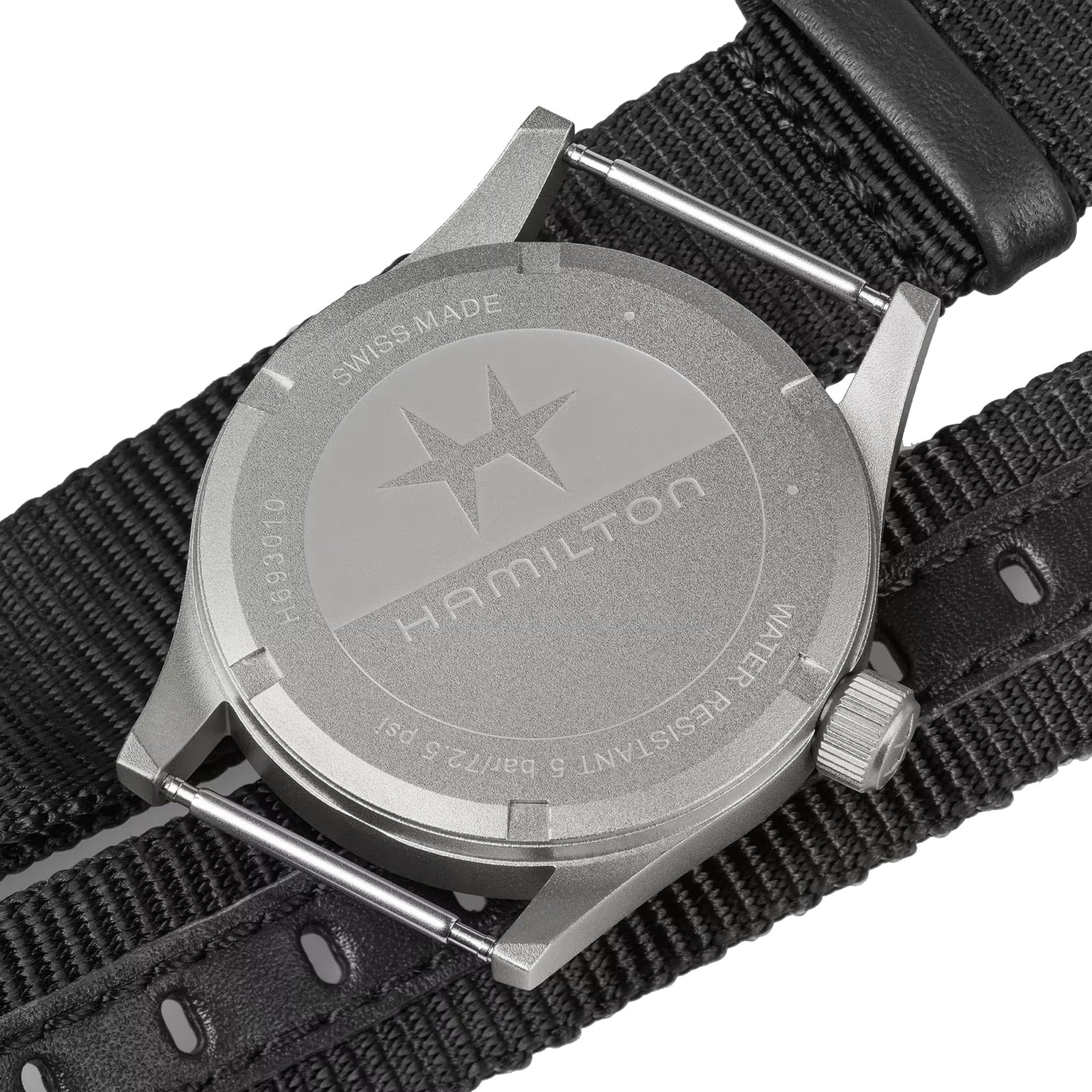 The back of a Hamilton Khaki Field Quartz 33mm watch features a stainless steel case, engraved details, and a robust black NATO strap that highlights its military heritage.