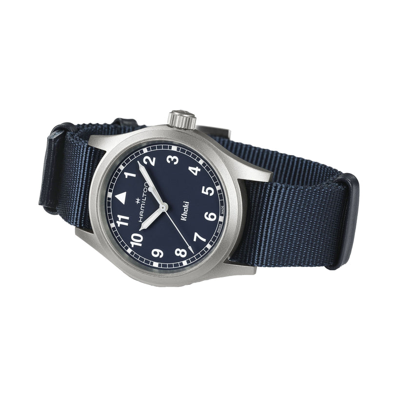 The Hamilton Khaki Field Quartz 38mm features a dark blue dial with white numerals, a silver case, and a navy blue NATO strap, displaying 10:09—reflecting its classic military heritage.