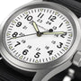 Close-up of the Hamilton Khaki Field Mechanical watch featuring a white dial with black numerals, 24-hour markings, luminous hands, and a rugged black NATO strap that highlights its military origins.