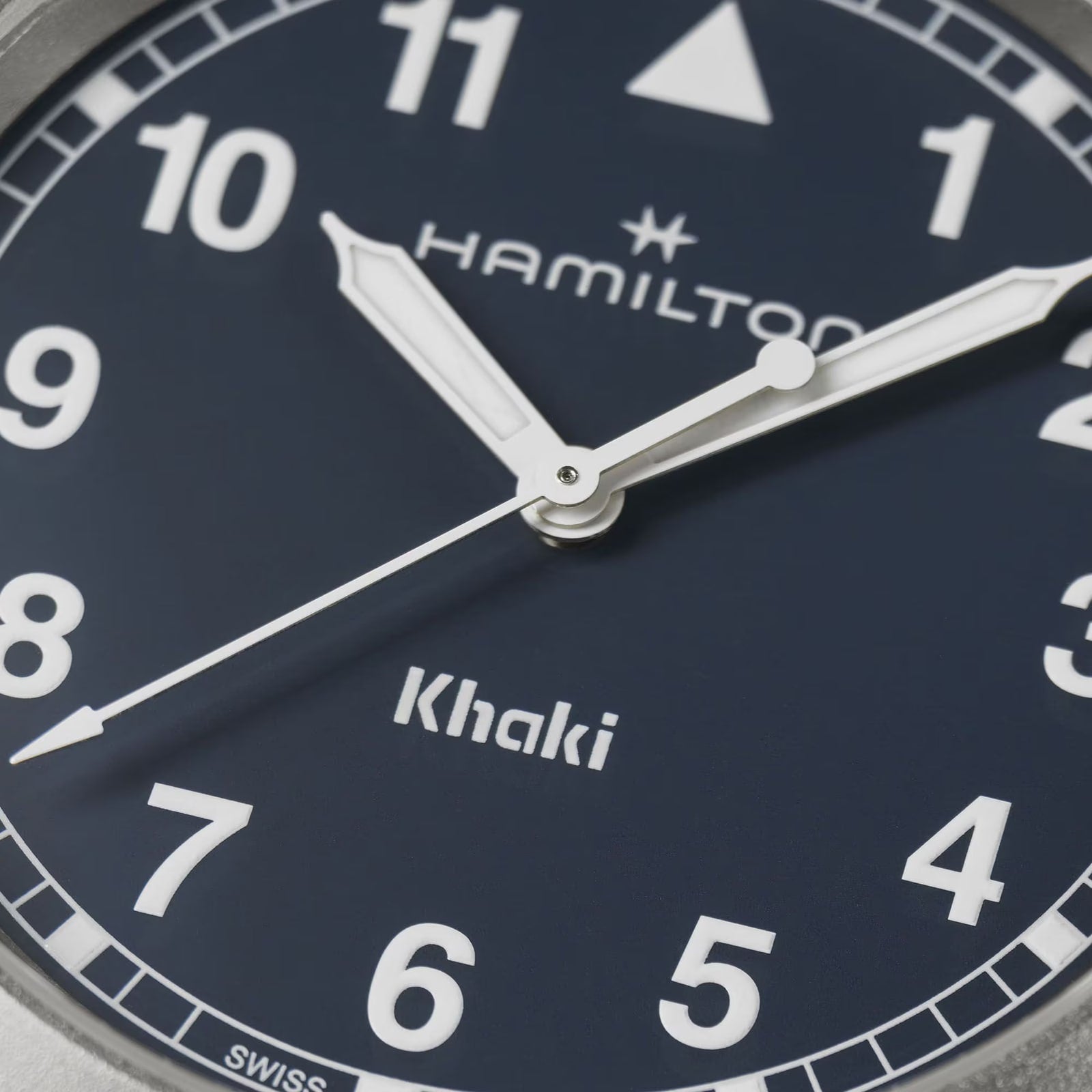 Close-up of the Hamilton Khaki Field Quartz 38mm watch featuring white hands and numerals on a dark blue dial.
