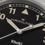 Close-up of a Hamilton Khaki Field Quartz 38mm watch face with beige hour markers and hands, showing partial view of 10 and 11.