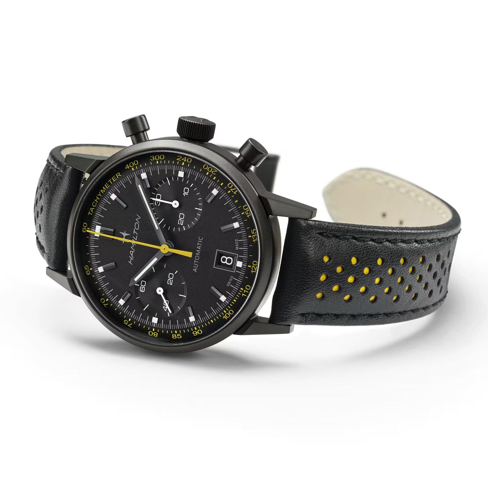 The Hamilton American Classic Intra-Matic Auto Chrono is a black chronograph watch with a black leather strap, yellow perforations, and tachymeter markings.