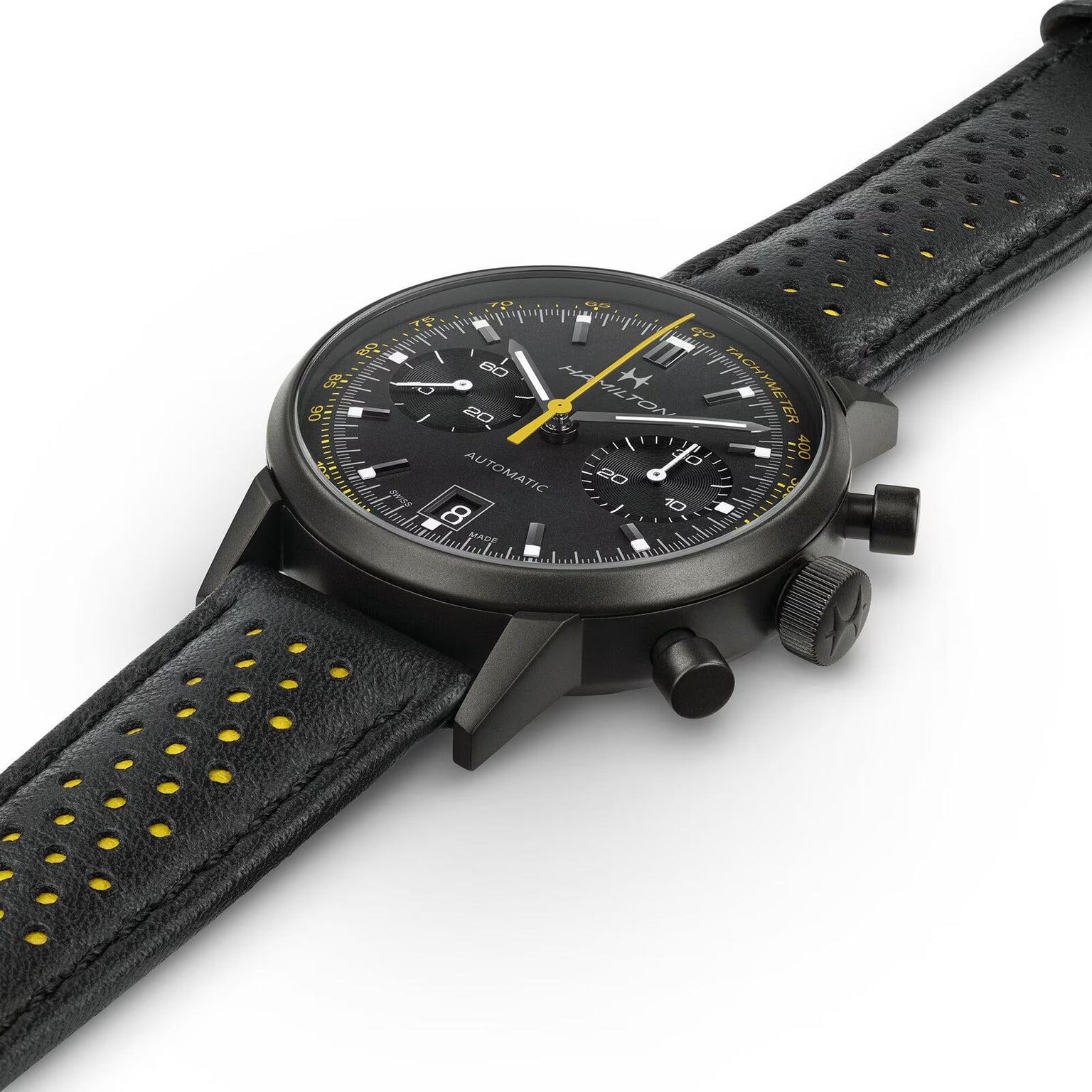 The Hamilton American Classic Intra-Matic Auto Chrono is a black chronograph wristwatch with yellow accents and a perforated leather strap, displayed on a white background.