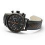The Hamilton American Classic Intra-Matic Auto Chrono is a black chronograph wristwatch with a black leather strap featuring orange perforations and an orange second hand.