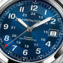 Close-up of a blue Hamilton Khaki Field Auto 38mm watch displaying 2:08, featuring a date window at 3 o’clock.