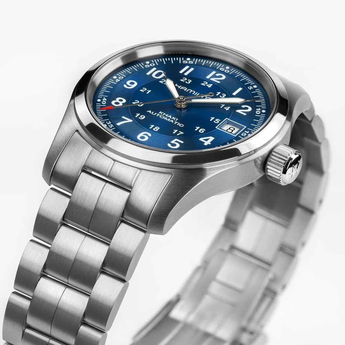 The Hamilton Khaki Field Auto 38mm wristwatch features a silver strap, blue dial, and white Arabic numerals, displayed at an angle.
