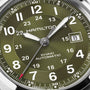 Close-up of a green Hamilton Khaki Field Auto 42mm watch displaying the date as the 8th.