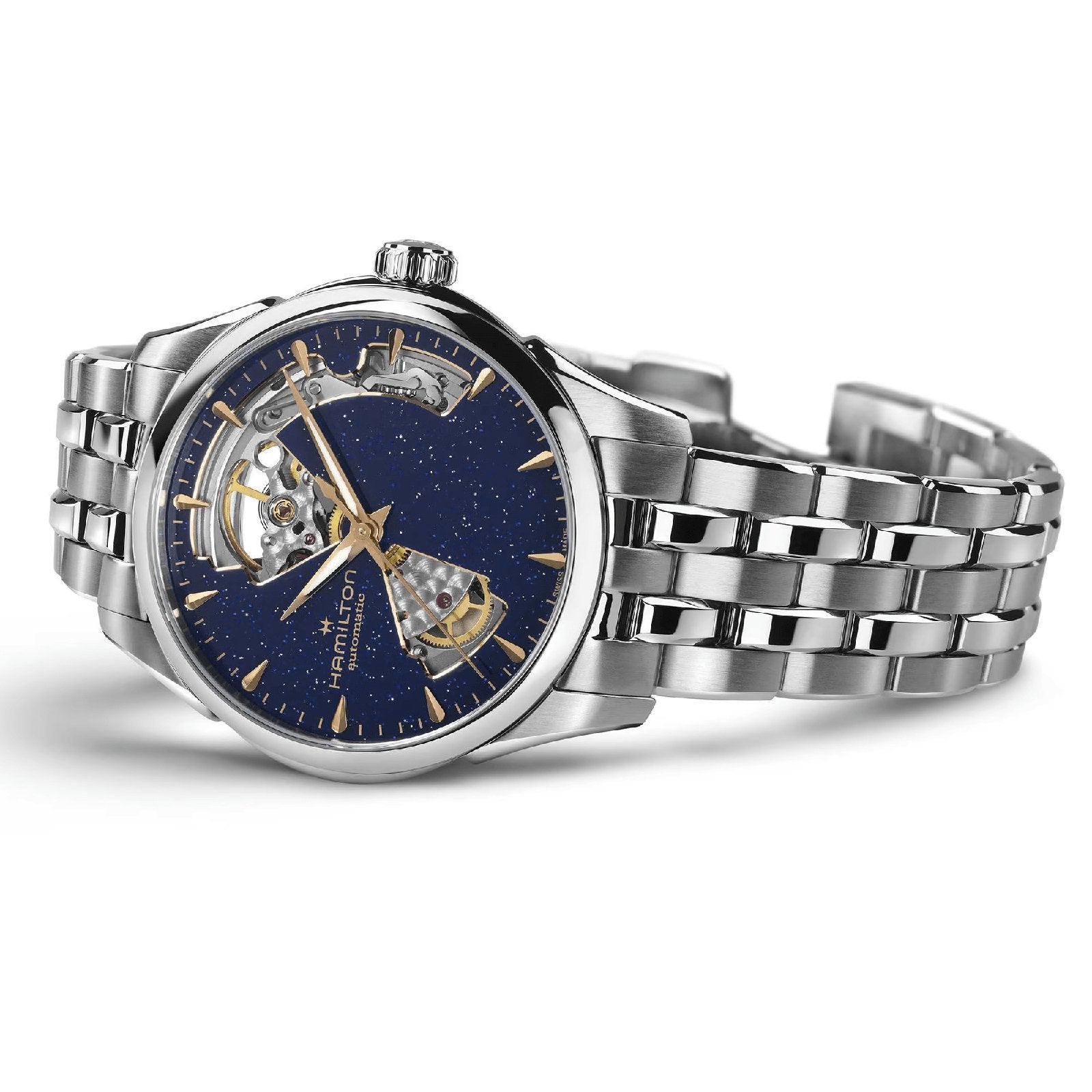 The Hamilton Jazzmaster Open Heart Lady Auto features a silver stainless steel bracelet and a blue open-heart dial with gold hour markers, showcasing the watchs visible internal mechanisms.
