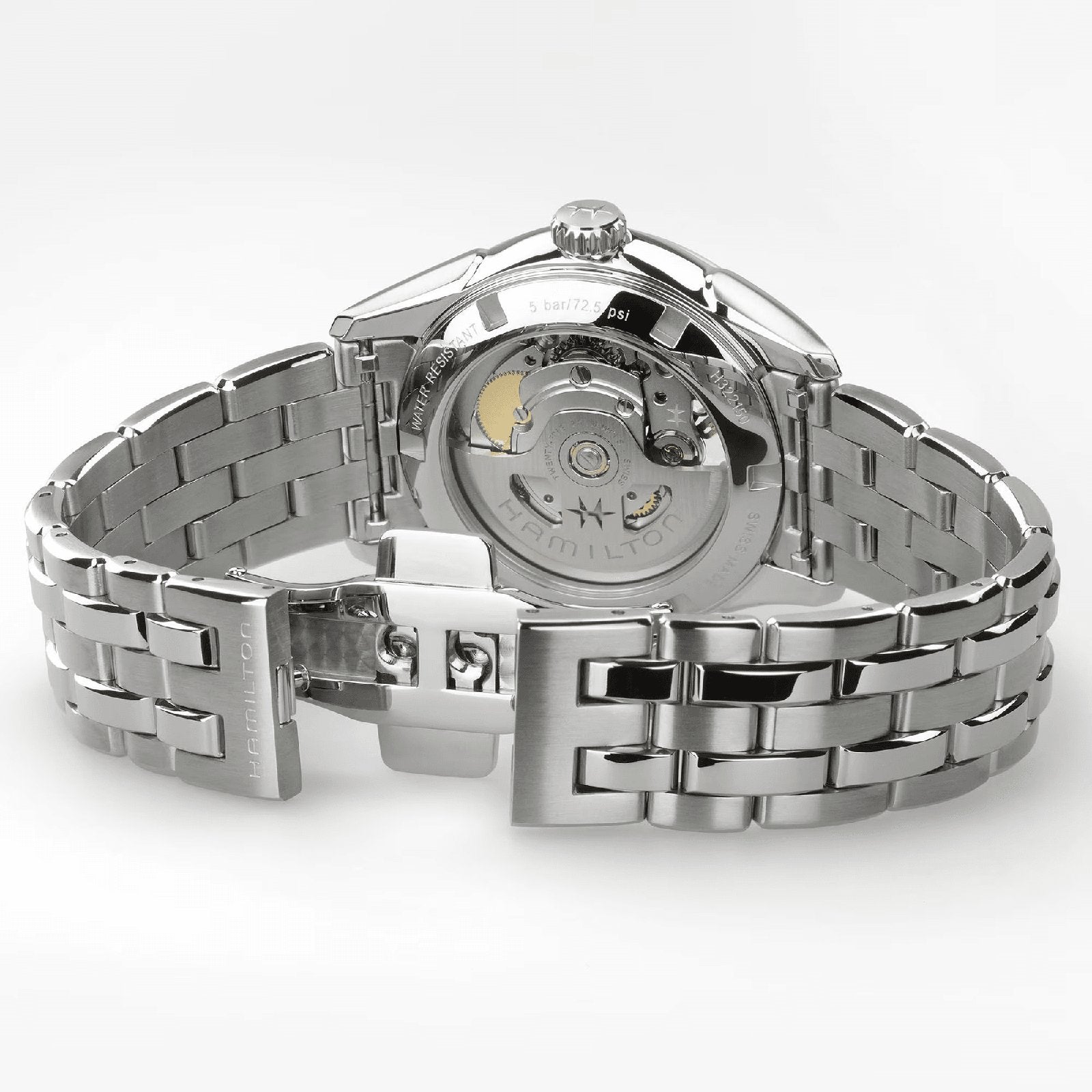 A close-up of the Hamilton Jazzmaster Open Heart Lady Auto wristwatch, featuring a stainless steel bracelet, open clasp, and a transparent case back that reveals its automatic movement.