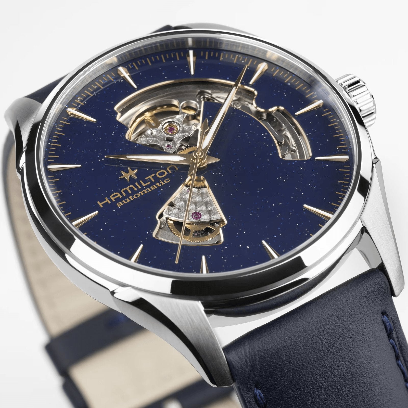 A close-up of the Hamilton Jazzmaster Open Heart Auto 42mm, featuring a blue starry dial, stainless steel case, partial skeleton design, and blue leather strap—an exquisite dress watch choice.