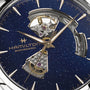 Close-up of the Hamilton Jazzmaster Open Heart Auto 42mm, featuring an open-heart blue dial with visible gears, automatic movement, and gold hands and indices.