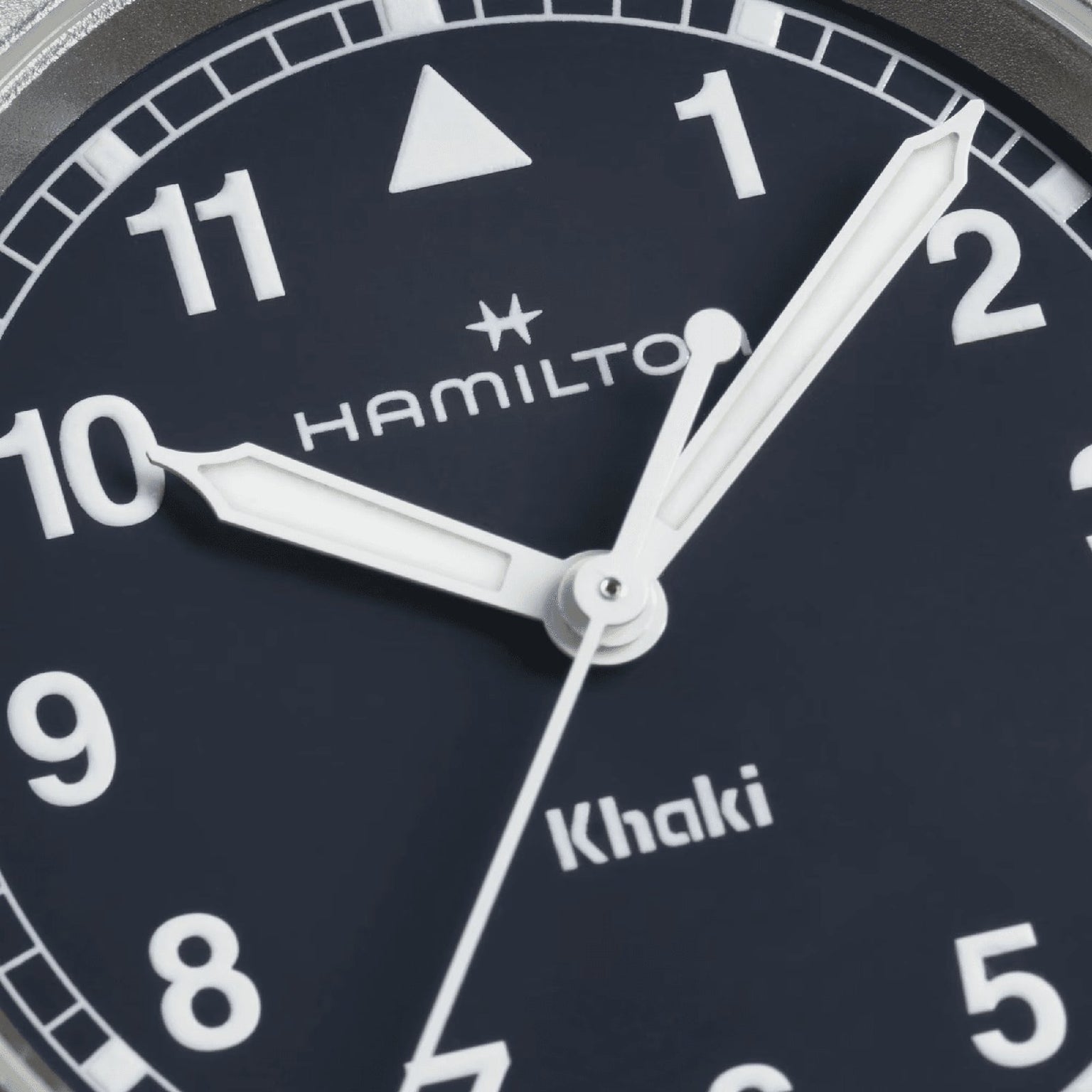 Close-up of a Hamilton Khaki Field Quartz 33mm watch face at 9:05:36, featuring white numerals and bold hands on a navy blue dial—an ideal adventure watch from Hamilton.