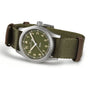 The Hamilton Khaki Field Quartz 33mm showcases an olive green dial, white numerals, and a green nylon strap with brown leather accents, embodying the brand’s military heritage and robust design.