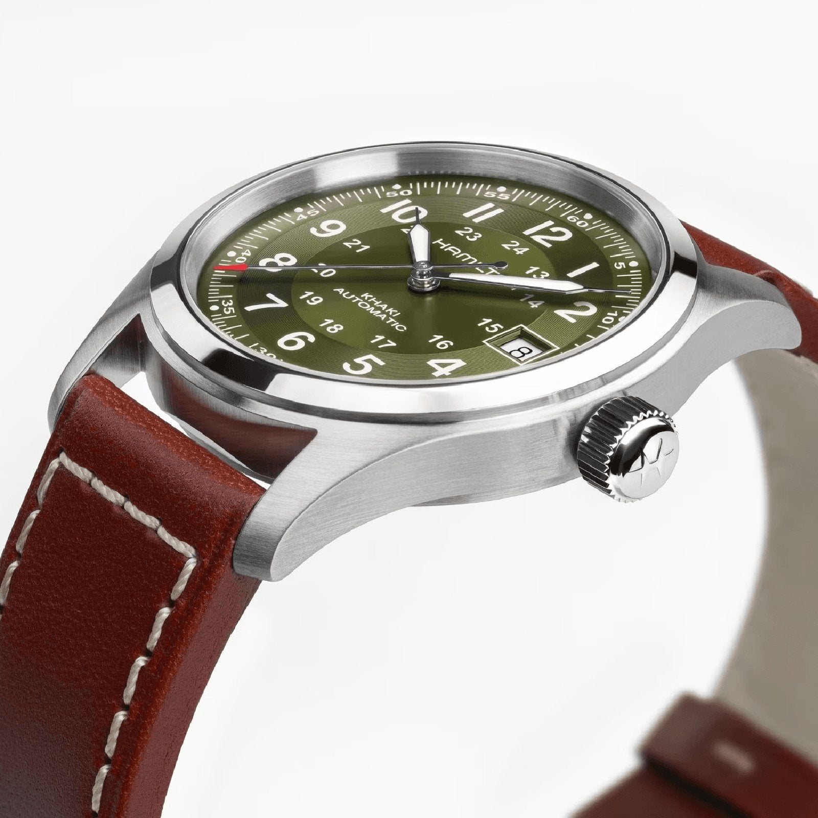 A close-up of the Hamilton Khaki Field Auto 38mm, featuring a green dial with white numerals, date display, stainless steel case, and a brown leather strap with white stitching—reflecting its military-inspired design.